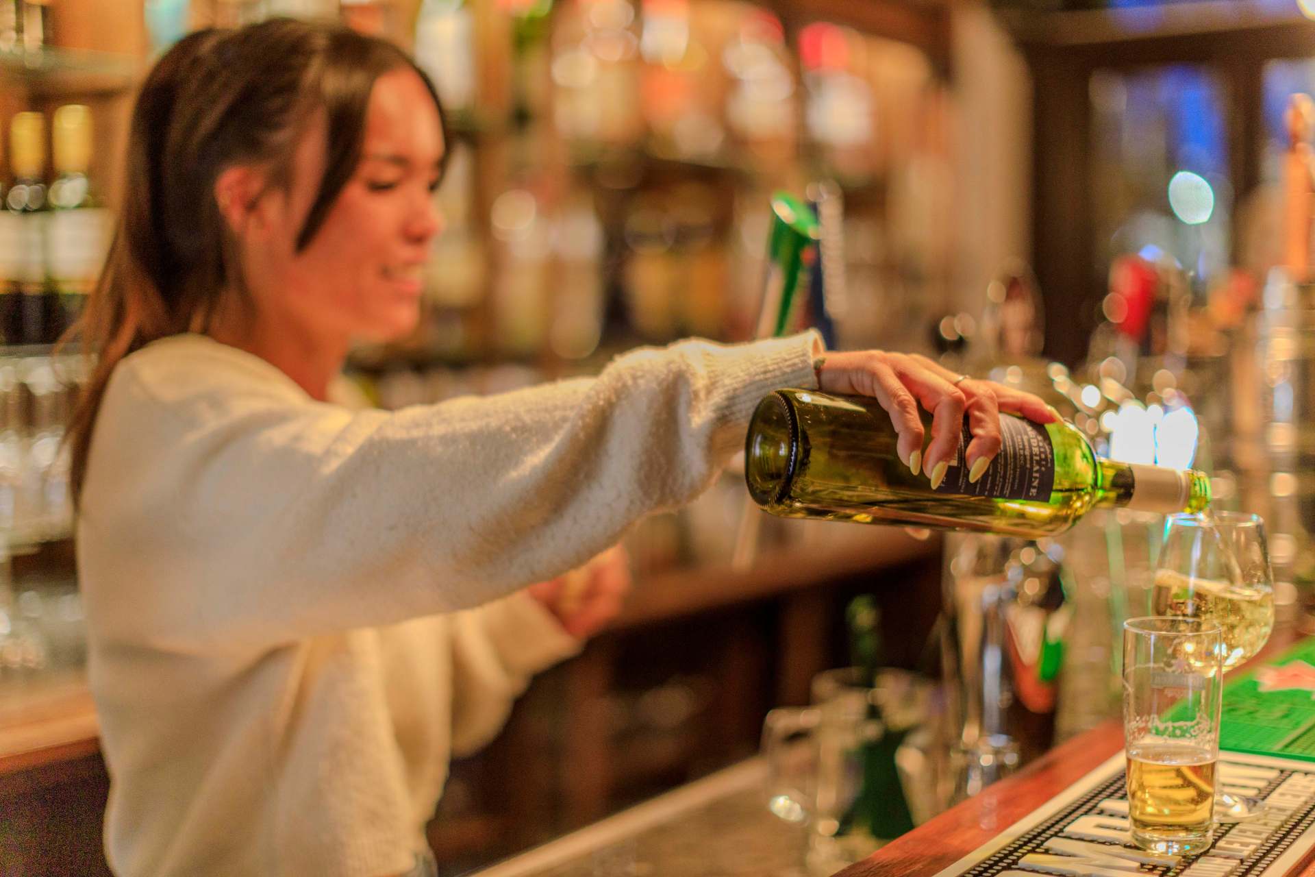 Wijn wordt ingeschonken aan de bar van DE HATHOR